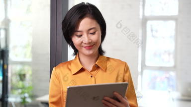 年轻商务女士使用平板电脑露齿一笑信心影像