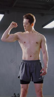 健身房里展示肌肉的青年男人
