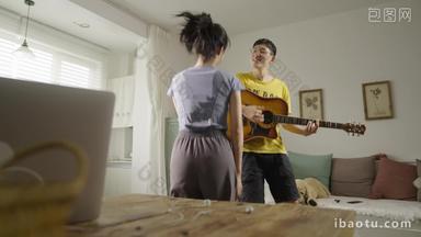 年轻情侣在家里弹吉他跳舞