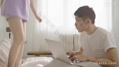 年轻<strong>情侣</strong>坐在床上用电脑