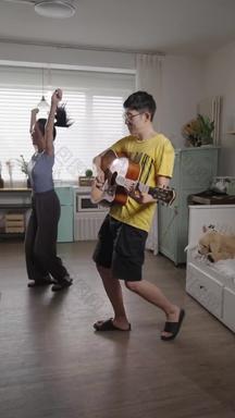 年轻情侣在家里弹吉他跳舞