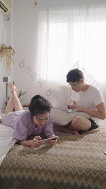 年轻<strong>情侣</strong>在家使用手机和电脑