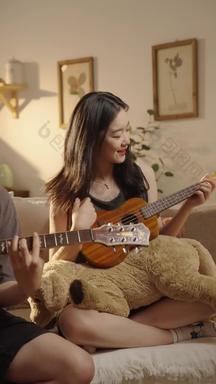 年轻情侣在家里弹吉他