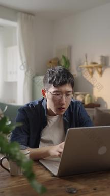 年轻男人在家使用电脑画面