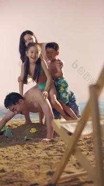 幸福的四口之家在沙滩上玩耍