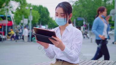 青年女人戴着口罩使用平板电脑