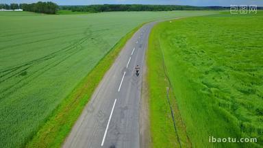 航拍骑行在田间公路、乡村公路