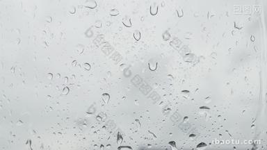 阴天下雨雨滴在玻璃窗滑落滚动