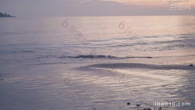黄昏日落海浪拍打到沙滩上特写