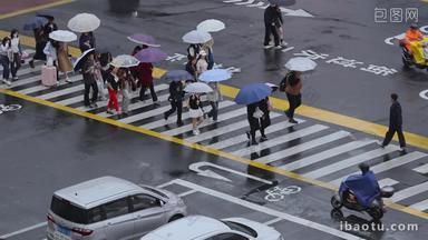 雨天繁华街道路口行人过马路