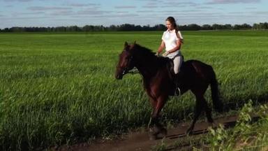 年轻女子骑手骑着马在球场上