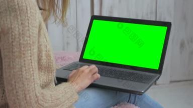 使用带有绿色屏幕的笔记本电脑的妇女