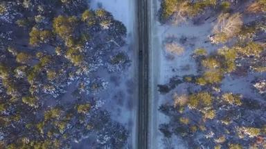 一辆汽车在乡村公路上开车穿过冬季的森林。无人机的顶视图。通过在冬天用雪<strong>覆盖</strong>了树山高处林区<strong>道路</strong>鸟瞰图