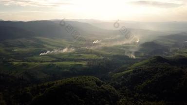 空中无人机镜头视图: 飞越秋季山村森林, 田野和河流在日出柔和的光.