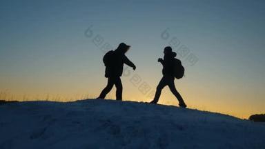 登山者在雪山<strong>山顶</strong>相遇, 享受他们的成功, 举起双手快乐地跳。男人游客背着背包在冬天的日落到达<strong>山顶</strong>。体育旅游理念