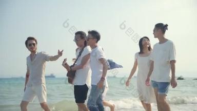 <strong>一群</strong>年轻的亚洲成年人男人和<strong>女人</strong>有乐趣步行在海滩上唱歌, 后视镜.