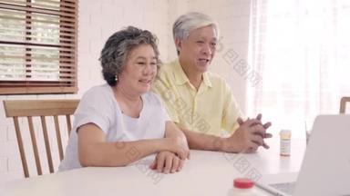 亚裔老年夫妇使用笔记本电脑与医生在客厅里谈论医学信息，夫妻俩一边躺在家里的病床上一边。家庭家庭健康概念.