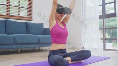 年轻的亚洲少女使用虚拟现实模拟器，同时在客厅练习瑜伽，<strong>女性</strong>锻炼<strong>健康</strong>在家里。生活方式<strong>女性</strong>锻炼未来技术理念.