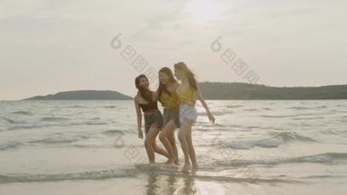 一群亚洲年轻女性在沙滩上散步，<strong>朋友</strong>们开心地放松一下，在傍晚日落时在海边的海滩上玩耍。生活方式<strong>朋友</strong>旅游假期暑假概念。慢动作拍摄