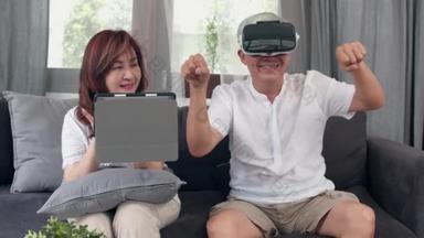 亚洲老年夫妇使用平板电脑和虚拟现实模拟器在客厅玩游戏，<strong>夫妻</strong>俩一起开心地躺在家里的病床上。<strong>生活方式</strong> 高级家庭概念。慢动作.