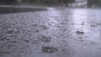慢动作关闭：秋天的雨滴落在沥青路面上的大水坑里，淹没了街道。雨季下大雨，导致道路被淹。雨滴落在被淹没的道路上