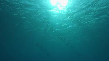慢动作，水下，Pov：在溺水之前游到<strong>翡翠</strong>海洋的闪闪发光的表面。 明亮的太阳光穿过闪烁在<strong>翡翠</strong>大海中的照相机前的玻璃般的波浪.