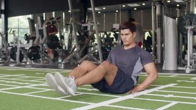 一个年轻英俊的亚洲小伙子躺在健身课上做仰卧<strong>起坐</strong>脂肪燃烧锻炼。 运动员六包，运动员娱乐活动，功能训练，健康生活方式概念.