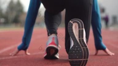 一个年轻运动员在跑道上准备赛跑的背景图.