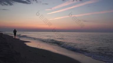 在日出时分，一个人平静地沿着荒芜的海滩走着。海景