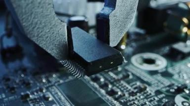 工作中的工厂机器：用机械臂组装的印刷电路板、连接微芯片的表面安装技术、 CPU处理器和主板。关注宏观层面的密切关注