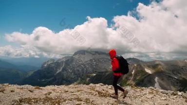 <strong>受到</strong>鼓舞的女游客背着背包爬上高山的最高峰，接近悬崖，喜欢从山上征服山顶和山谷中的风景，两臂张开。积极的生活.