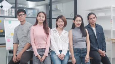 亚洲集团的年轻创意人士，穿着时髦休闲装，双臂交叉地出现在富有创意的办公室工作场所。不同的亚洲男性和女性在创业时站在<strong>一起</strong>。同事团队精神概念.