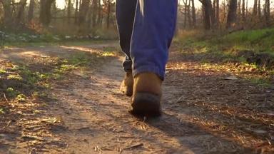在森林的小径上走着一双穿着靴子的男性小腿