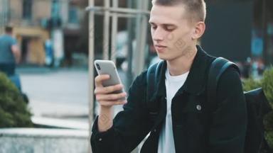 追踪学生在城市街道上使用智能手机享受无线网络通讯的照片。年轻学生<strong>放学</strong>后休息
