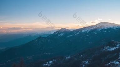 时光流逝：夕阳西下的阿尔卑斯山，独特的风景全景，高山山谷移动的云彩，冬季.