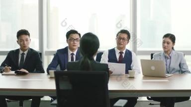 一个年轻的亚洲女商人在现代公司的会议室接受一群<strong>人力资源</strong>经理的采访