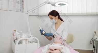 美容师用这种药膏按摩病人的脸部和颈部。特写。美容师在美容科诊所的病人脸上擦奶油.