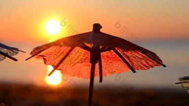 日落时分，海滨<strong>沙滩</strong>上的纸制鸡尾酒雨伞.