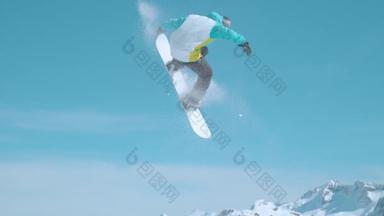 慢动作：极限运动的滑雪者在空中飞舞，做一个抓举动作.