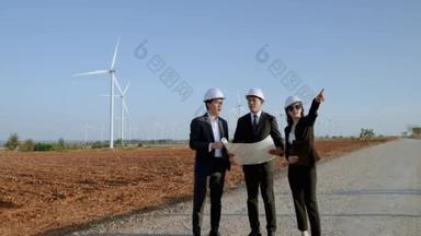 检查员和一个有秘书的工程师正在视察一个风力涡轮机发电场的一个项目。清洁能源概念、可再生能源、拯救世界.