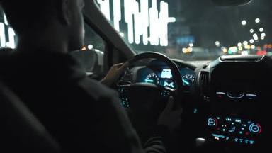 男人开车穿过夜城的街道。从车子的后座上看.