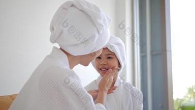 母亲和女儿在脸上涂了血清,家庭美容疗法.早上的日常护理。青少年皮肤问题.