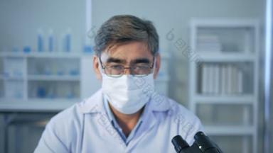 在医学实验室里戴着无菌面具看着相机的亚洲高级医生的画像。<strong>研究人员</strong>概念。近视；近视.