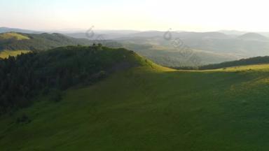 一架无人驾驶飞机飞越高山高地的绿色草地。以UHD 4k视频拍摄.