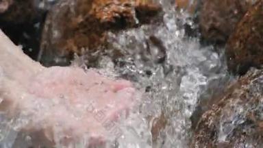 手握干净的飞溅瀑布在森林的河流或湖中。清澈的水花倒入手心里.水滴，水资源，土地，环境。保护自然资源.