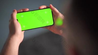 一个男人用双手横向地拿着智能<strong>手机</strong>。绿色<strong>屏幕</strong>用于键入模型。跟踪准备好的慢动作视频