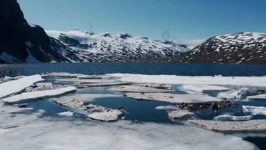 无人驾驶飞机飞越冰冻的湖面。水面上的冰块。冬日湖中的高山
