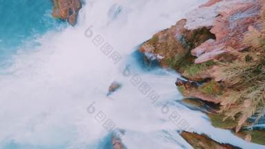一场暴风雨从悬崖上滑落下来.顶部视图。蓝色的水。泡沫。岩石。野生动物。空中无人机视频镜头。高质量的4k镜头
