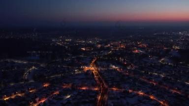 Flight over a city illuminated by a sunset flare. City lantern lights from above. A small town from 
