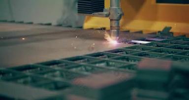 带火花的等离子激光切割金属片，工业生产中用于高精度切割和成形金属的精密制造工艺